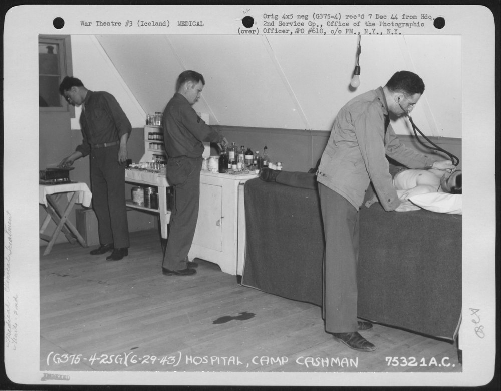 A doctor examines a 2nd Service Group member in the hospital at Camp