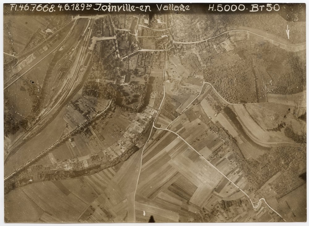 Aerial photograph of railway station with train departing south
