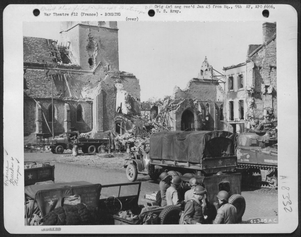 American troops move in on a bomb damaged city somewhere in France