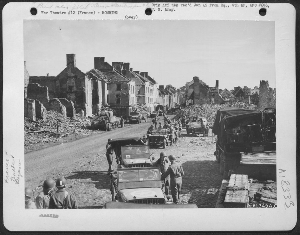 American troops move in on a bomb damaged city somewhere in France