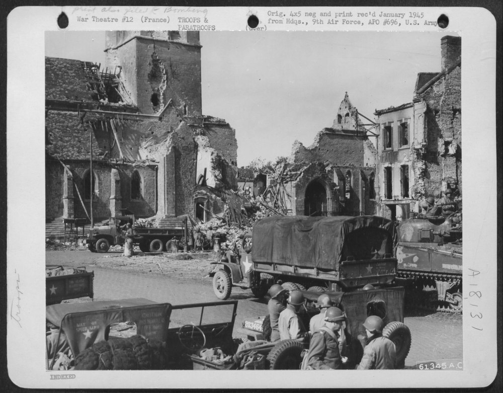 American troops move in on a bomb damaged city somewhere in France