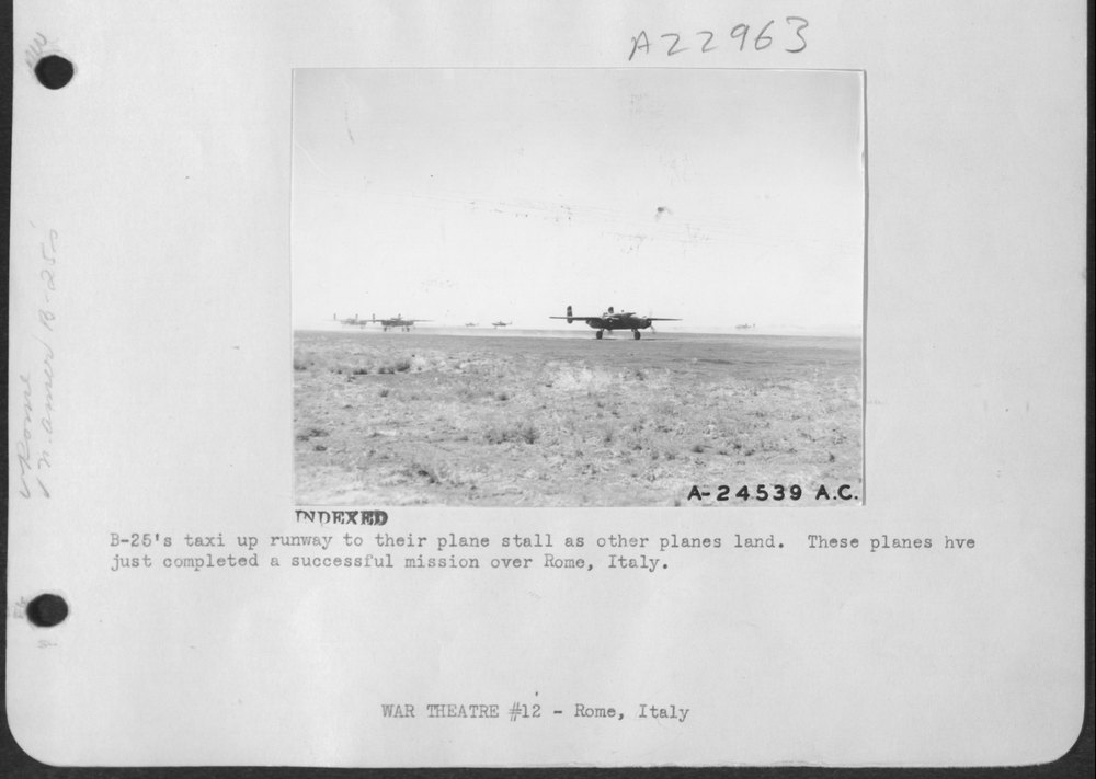 B'25's taxi up runway to their plane stall as other planes land