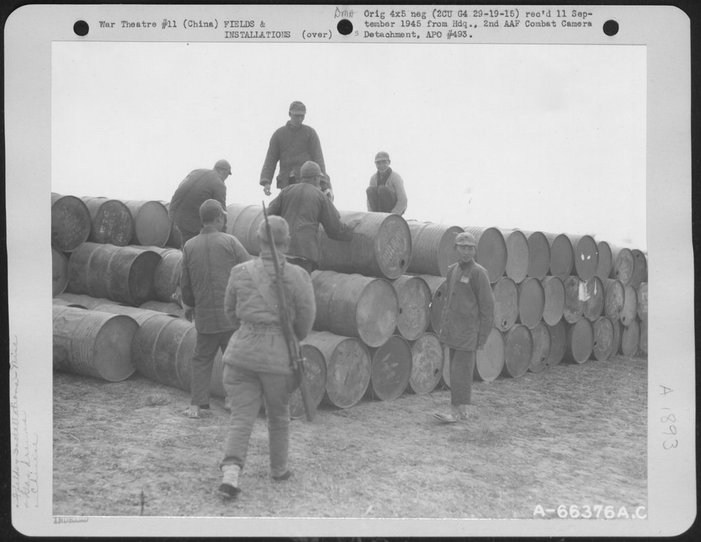 Chinese Coolies Stack Drums At B-29 Base