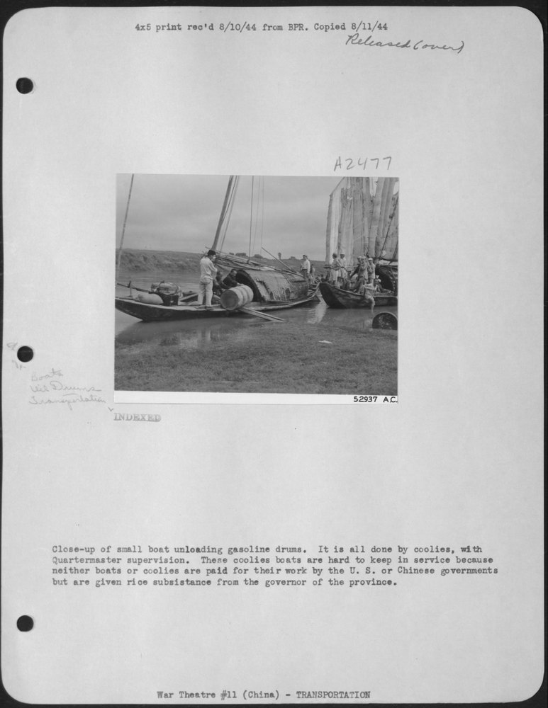 Coolies unloading gasoline drums