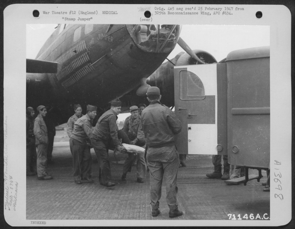 Crew member carried from B-17 in England