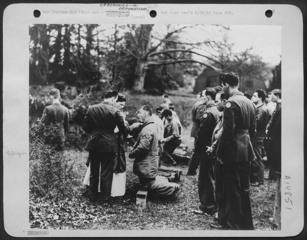 Enlisted men receive communion at fighter station