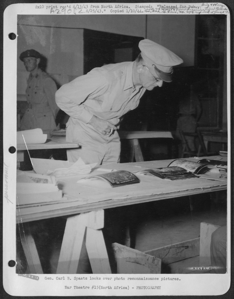 Gen Carl B Spaatz looks over pictures