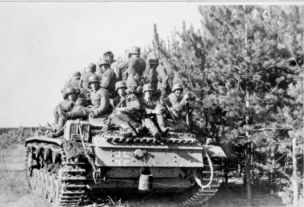 German soldiers ride on a tank