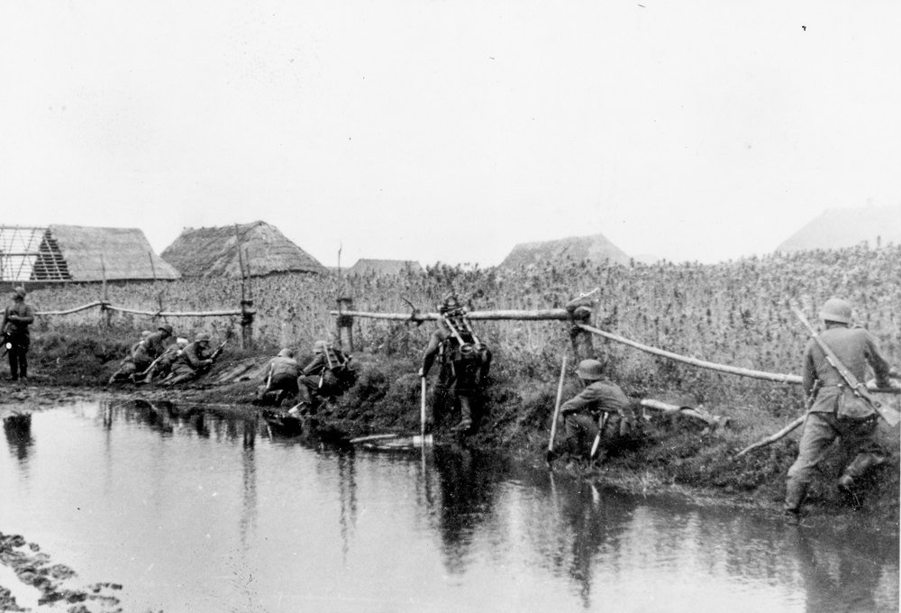German soldiers take cover along a river bank - The Battle for Glosoff