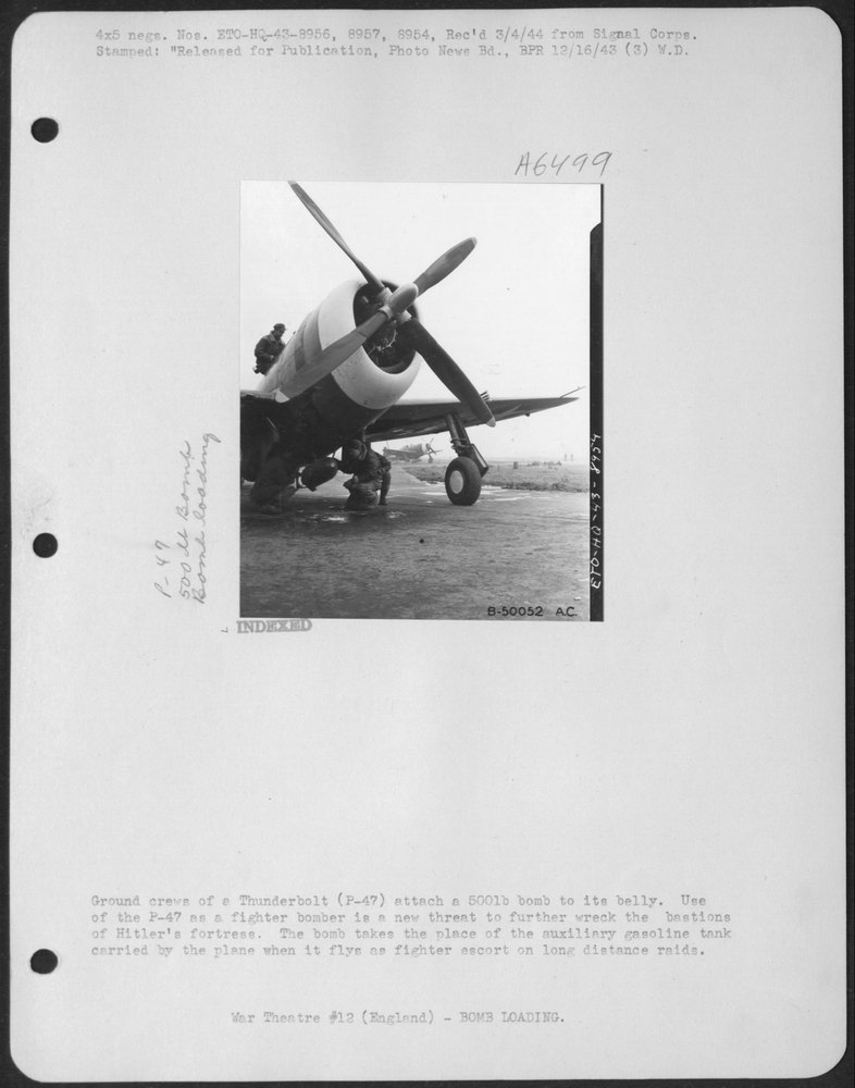 Ground crews of a Thunderbolt (P-47) attach a 500 lb bomb to its belly