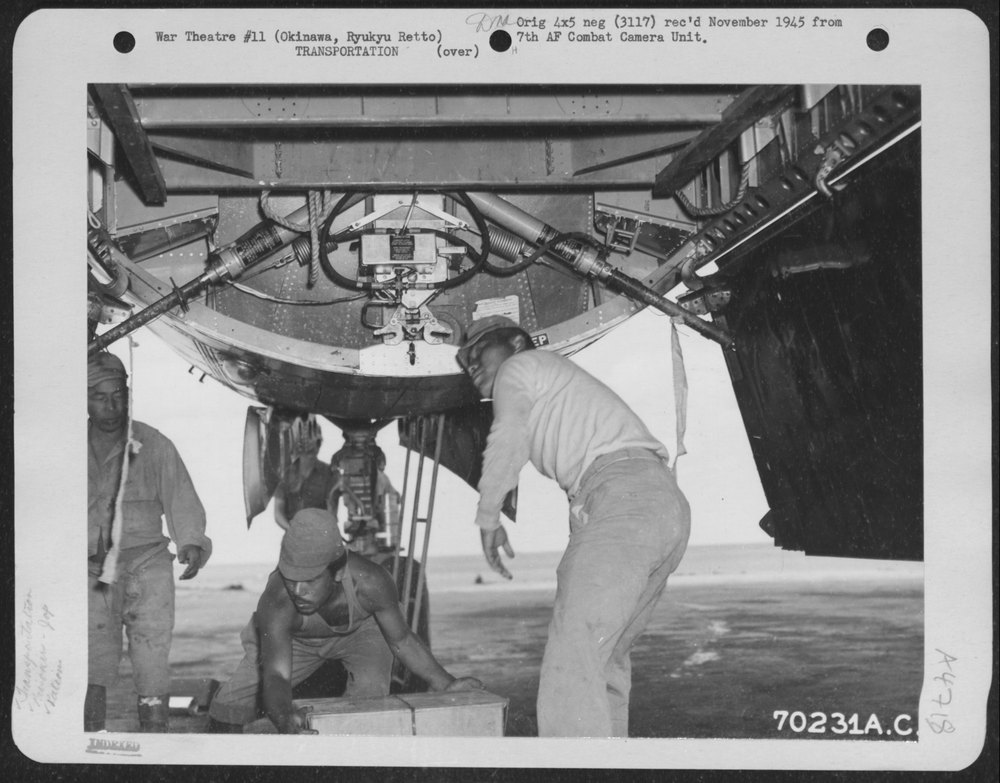 Japanese Prisoners Of War Unload Food Rations Through The Bomb Bay
