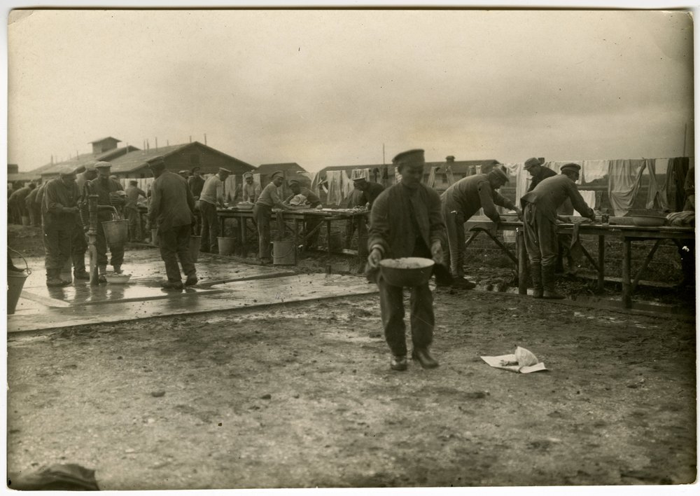 Men in uniform washing clothes outdoors