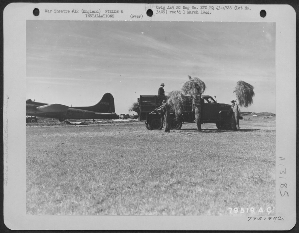 Men load hay at Chelveston Airfield