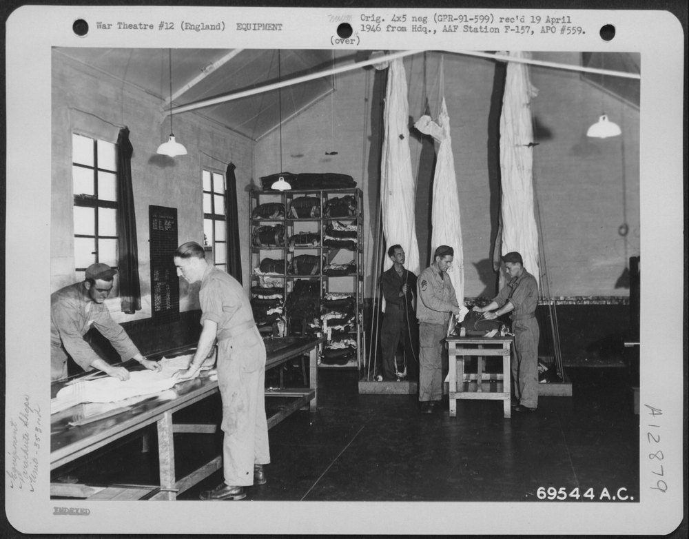 Men repack parachutes in England