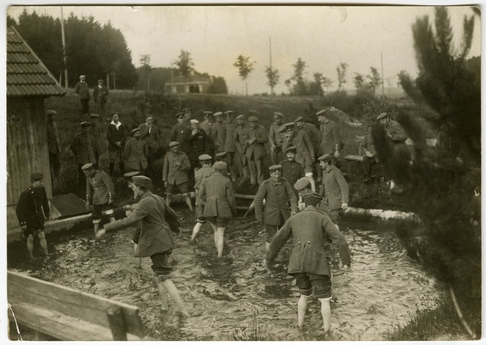 Men wading in shallow stream