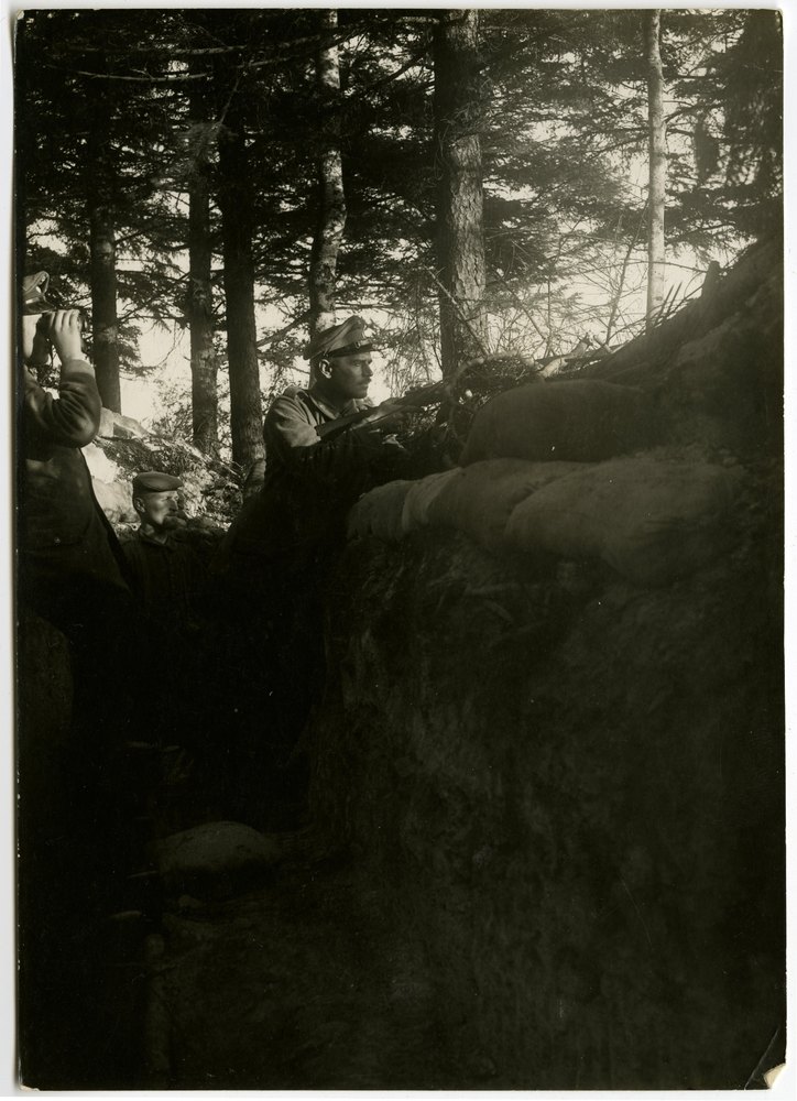 Men with rifle in wooded area