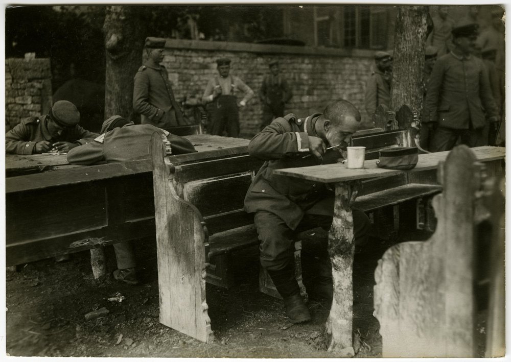 Military men at wooden tables outdoors