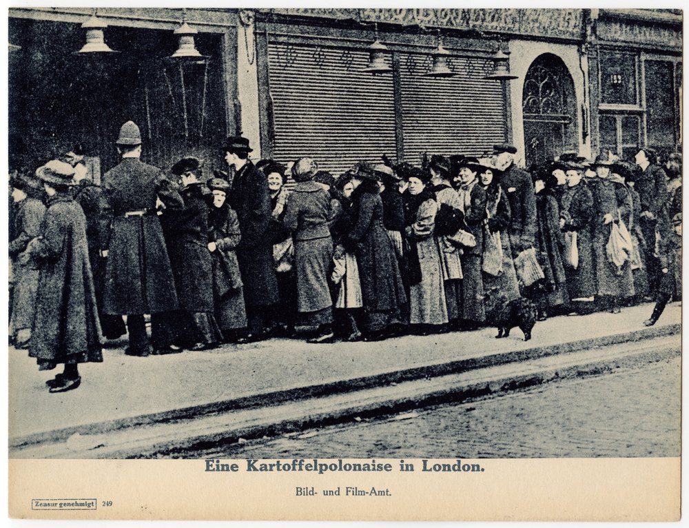 People queue on a London sidewalk
