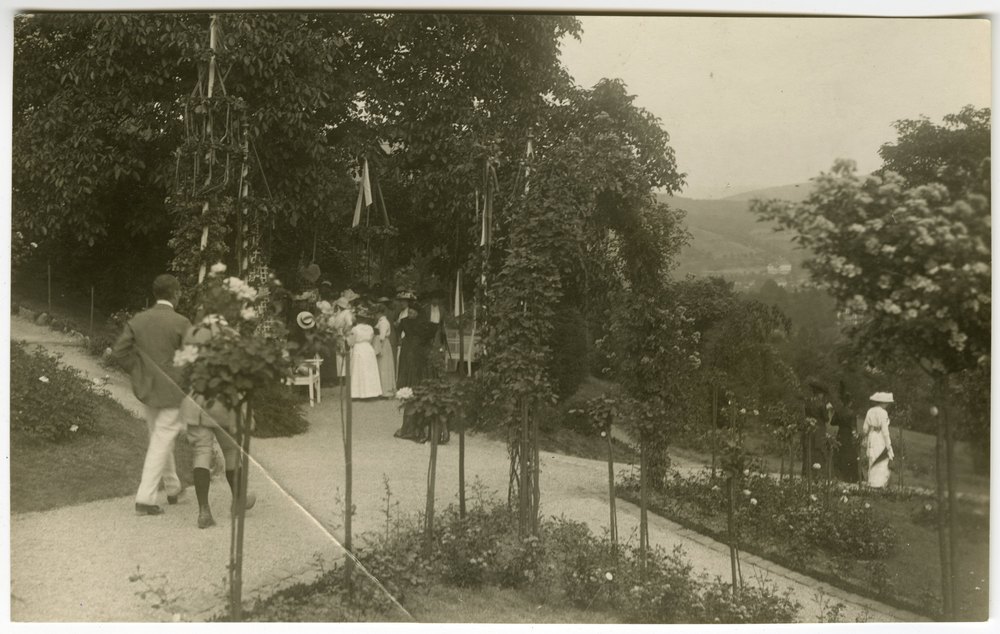 People walking on a gravel path in a garden