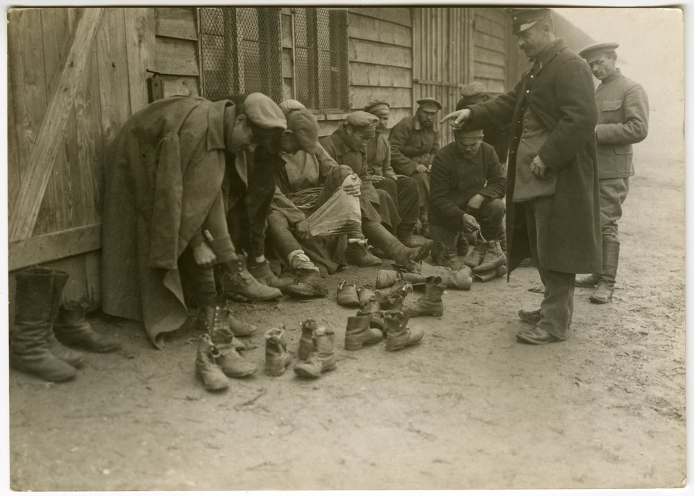 Prisoners' footwear and feet being inspected
