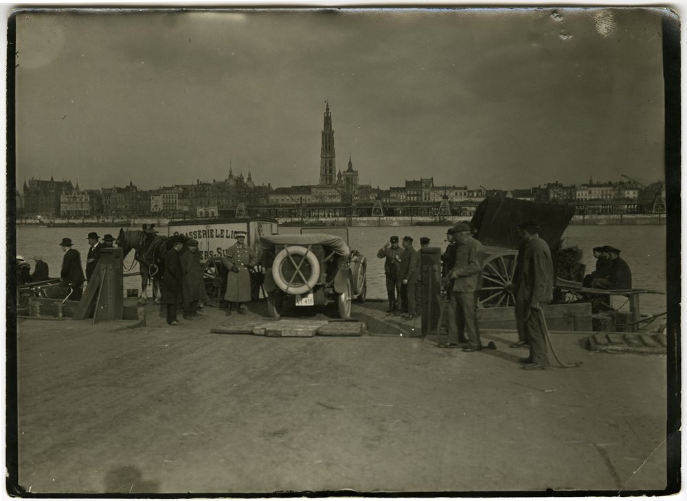 Riverside dock with horse-drawn cart and early automobile