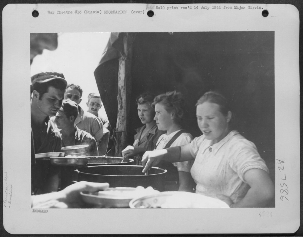 Russian women K.P.'s dish out C-rations plus a variety of Russian