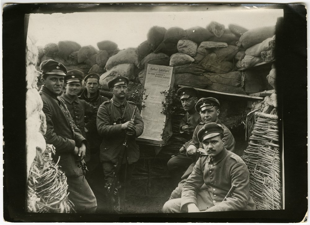 Soldiers in a trench with newspaper