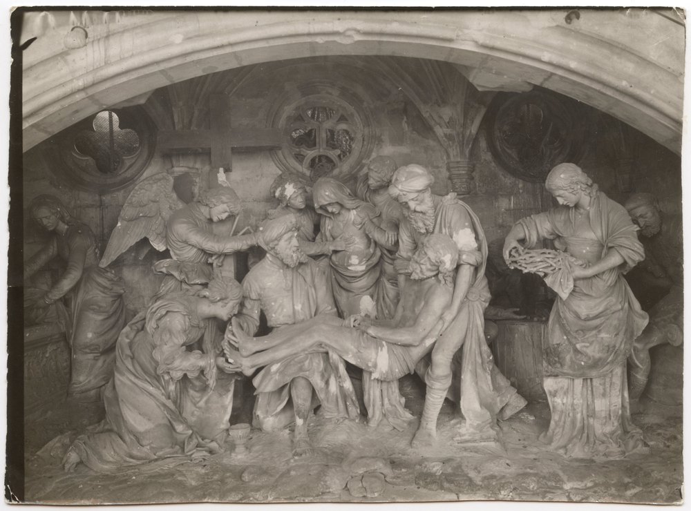 Stone sculpture of figures around a central figure on a bier
