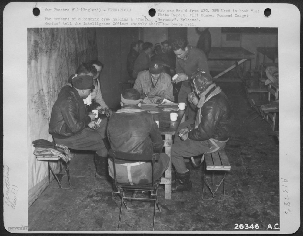 The members of a bombing crew holding a "Post Germany Mortum" tell